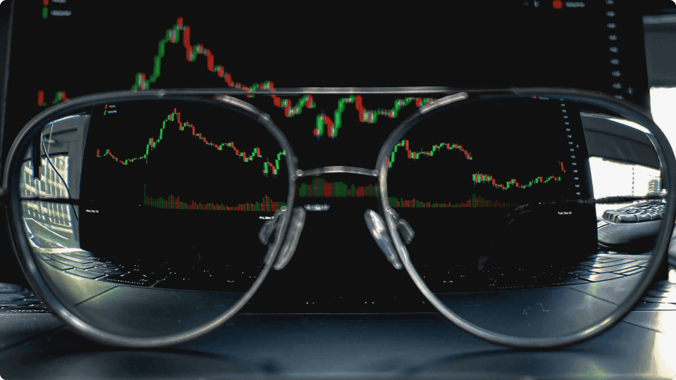 an image of Pair of glasses in front of a stock monitor screen