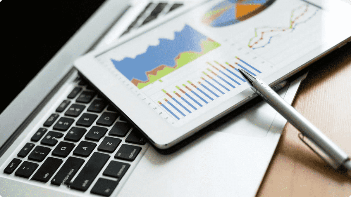 an image of 1280 x 720 Stock_charts_above_laptop_showing_investment_indicators